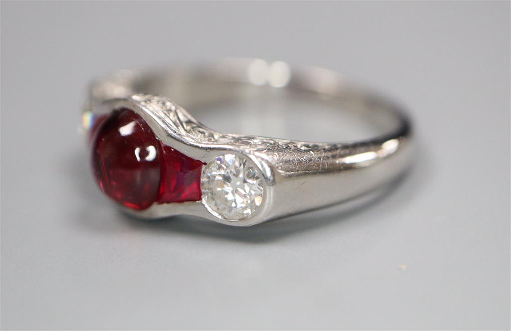 A modern white metal (possibly platinum?), ruby and diamond dress ring,